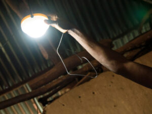 A person adjusts a hanging light fixture