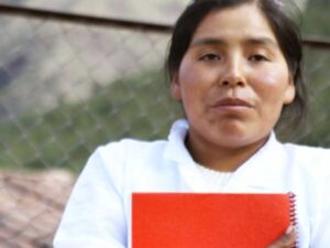 A woman holds a red notebook