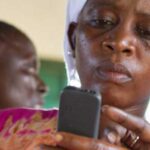 A woman checks information on a mobile device