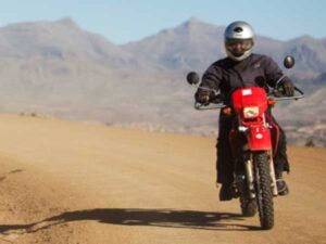 A person rides a motorbike on a dirt road