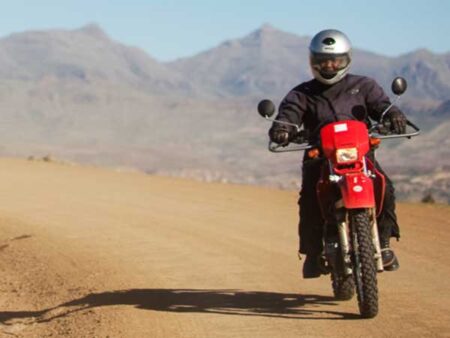 A person rides a motorbike on a dirt road