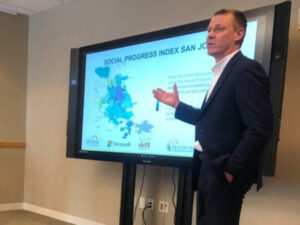 A man presents a slide titled Social Progress Index San Jose