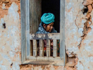 A women sits beside a window