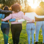 A group of people put their arms around each other